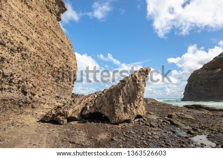 Stunning scenery of rock stone cliff with unique rock boulder on the small island in the ocean. Bethells beach, Te Henga, Auckland, North Island New Zealand