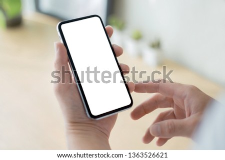 mockup image of cell phone white blank screen for text.Businessman at workplace Think business investment plan.Contact Investor using mobile,computer.make note appointment information in the notebook 