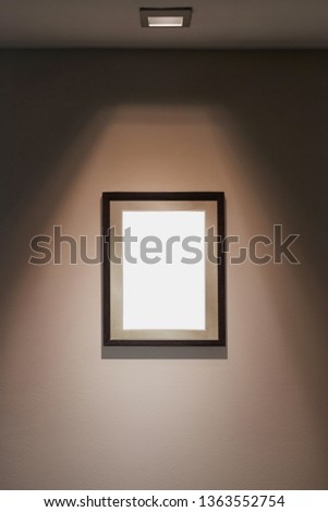 Empty picture frame on wall with spotlight for certificate display, blank white space