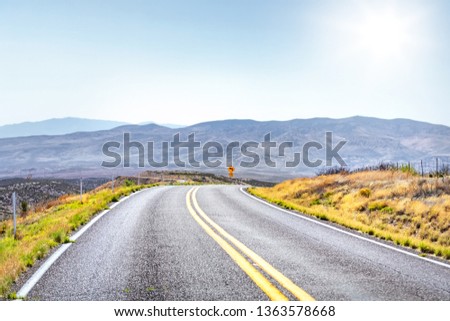 Dramatic perspective curve road with beautiful open field landscape.