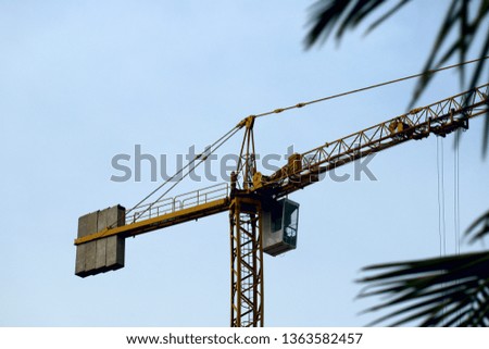 Fragment of a construction crane against the sky. Cropped shot, horizontal, a lot of free space for text. Concept of construction and technology.