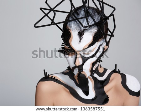 Female model with creative abstract makeup in futuristic hat.