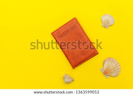 Travel vacation summer weekend sea adventure trip journey ticket tour concept. Minimal simple flat lay with passport and shell on yellow trendy modern background. Tourist essentials