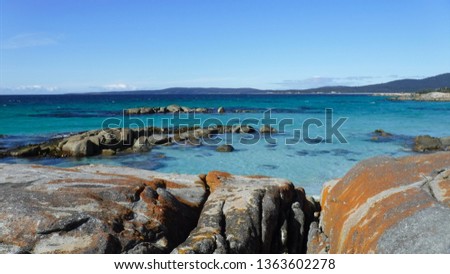 Landscape of orange-hued granite rocks in Bay of Fires on the northeastern coast of Tasmania in Australia.
