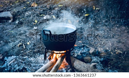 Boiling water in the bowler on the bonfire.