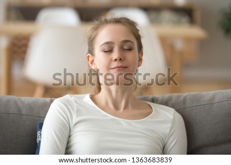 Close up calm peaceful woman relaxing with closed eyes or visualizing, sitting on comfortable sofa, breathing deep, tired girl fall asleep at home, lying on cozy couch, sleeping or taking nap Royalty-Free Stock Photo #1363683839