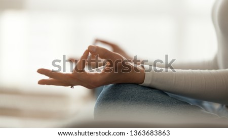 Close up peaceful woman sitting in lotus pose and meditating, practicing yoga at home, hands fingers view, calm girl controlling emotions, no stress, healthy lifestyle concept Royalty-Free Stock Photo #1363683863