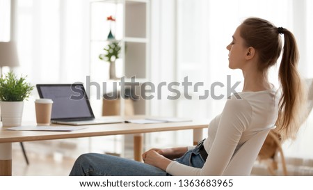 Calm peaceful young woman relaxing in office chair at workplace, tired employee sitting at desk, female student taking break after study, meditating with closed eyes, breathing deep, thinking Royalty-Free Stock Photo #1363683965