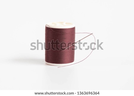The sewing threads spool with sewing needle isolated on white background