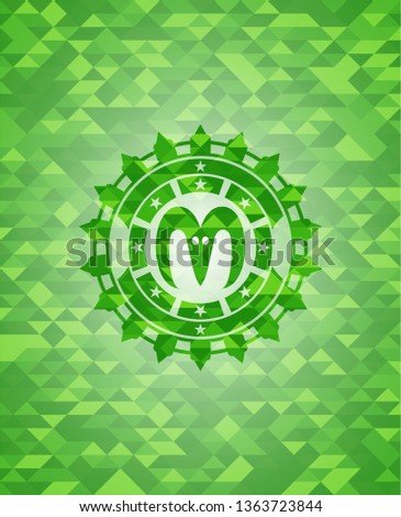 goat head icon inside green emblem with mosaic background