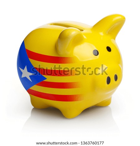 Piggy bank painted in the flag of Catalonia, isolated on white background