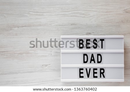 'Best dad ever' words on lightbox over white wooden surface, top view. Overhead, from above, flat lay. Copy space.
