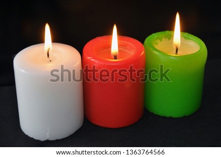 colorful burning candles set on black background. flame