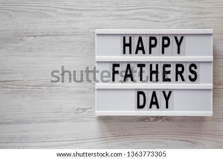 Modern board with 'Happy Fathers Day' words over white wooden surface, top view. Overhead, from above, flat lay. Copy space.