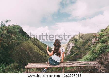 Bali Indonesia. Volcano Batur. Bali Island landmark. Tourist routes. Young woman on mountain top. Freedom concept