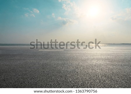 Empty asphalt road and blue sea with sky background