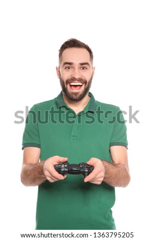 Emotional young man playing video games with controller isolated on white
