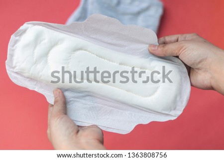 Woman holding a lot of panty liners on the pink background