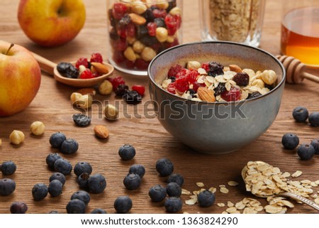 berries, nuts and muesli for breakfast on wooden table