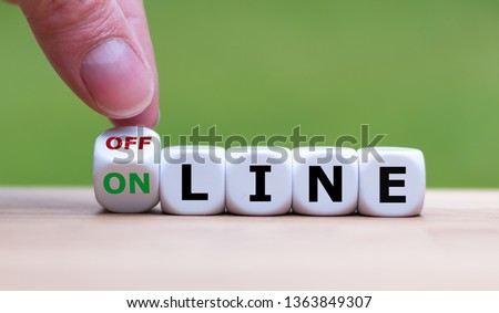 Hand turns a dice and changes the word "offline" to "online" (or vice versa).