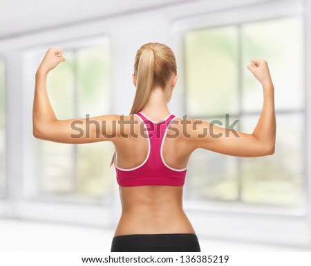 picture of young sporty woman showing her biceps