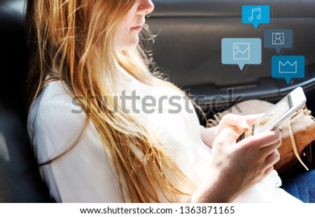 Pretty girl using her phone in a car