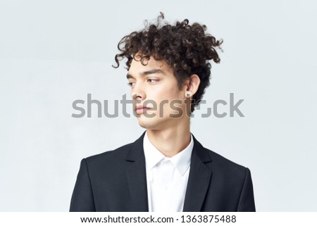  Young man in a suit, curly hair cropped look                              