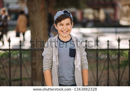 Handsome boy in cap walking in the city