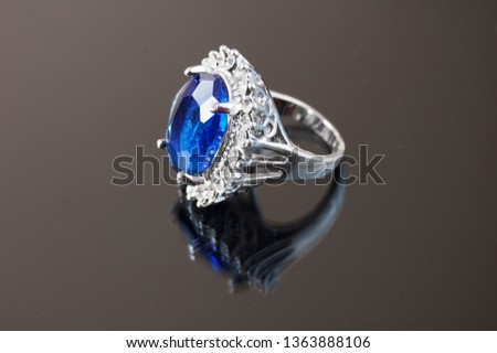 Silver ring with big sapphire and diamonds stones on black background