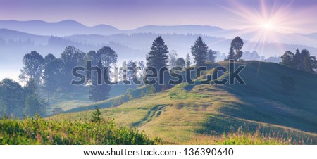 Panorama of the foggy sunrise in the mountains
