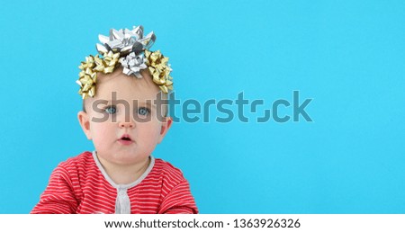 Baby decorated with a bow as a gift on a blue background