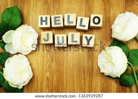 Hello July with tulip flower on wooden background