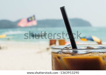Ice coffee with a malaysian flag on the background. Enjoying holidays concept