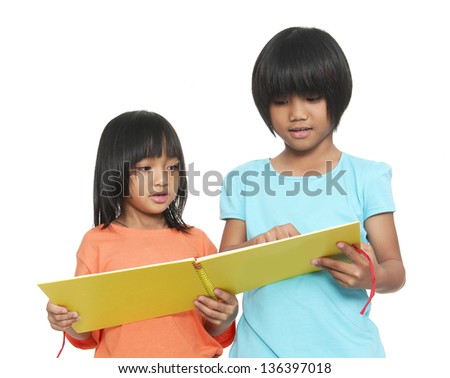 two little girls reading book standing on white background