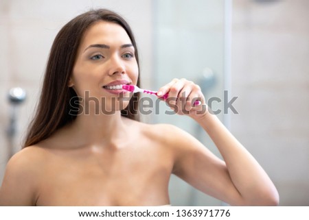 Attractive woman brushing her teeth keeping the hygiene of her mouth