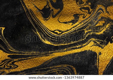 Golden swirl, artistic design. Suminagashi – the ancient art of Japanese marbling. Paper marbling is a method of aqueous surface design. Black and gold paper texture.  Royalty-Free Stock Photo #1363974887
