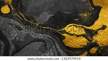 Golden swirl, artistic design. Suminagashi – the ancient art of Japanese marbling. Paper marbling is a method of aqueous surface design. Black and gold paper texture.  Royalty-Free Stock Photo #1363974914