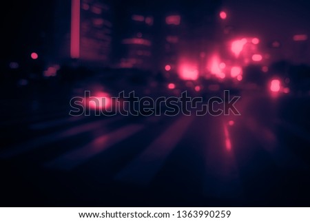 Perfect background image of blurred night street with unrecognizable people. Vintage looking image with washed out colors and red color cast