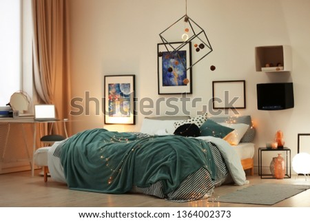 Stylish room interior with comfortable bed and decor