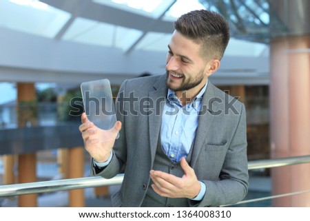 Future concept. Businessman holds futuristic transparent smart phone.