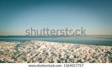 Snow pile on the beach, hill. Large snow drift isolated on a blue sky background, 
outdoor view of ice blocks at frozen finland lake in winter
 Royalty-Free Stock Photo #1364017757