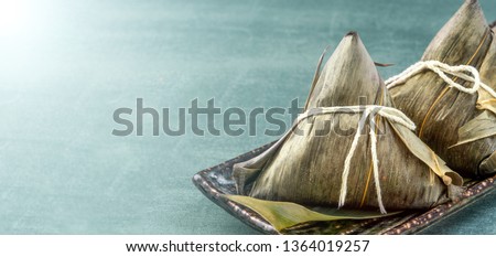 Zongzi - Close up, copy space, famous chinese food in dragon boat (duan wu) festival, steamed rice dumplings pyramidal shaped wrapped by bamboo leaves made by sticky rice raw ingredients