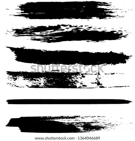 A set of brush strokes of black paint on a white background. Collection of abstract spots
