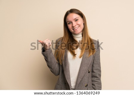 Young business woman pointing to the side to present a product