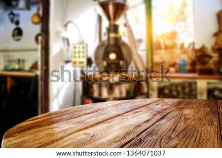 Wooden table background of free space for your decoration and coffee machine. Small plantation and summer sun light. 