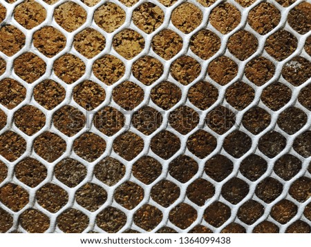 Closeup plastic mesh on gold or foil background texture 