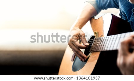 Close up of man's hands playing acoustic guitar. Musical instrument for recreation or hobby passion concept.
 Royalty-Free Stock Photo #1364101937