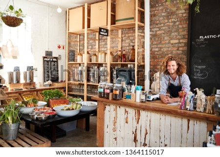 Portrait Of Male Owner Of Sustainable Plastic Free Grocery Store Behind Sales Desk