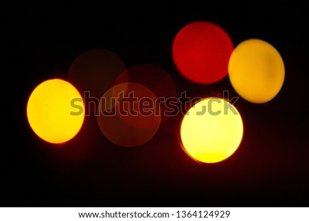 Bokeh lights abstract background in dark night colors. Photo. Large multi-colored round glare from headlights or lamps of red, yellow, orange shades at night