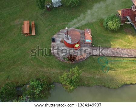 outdoor wooden barrel bath in summer homestead, aerial